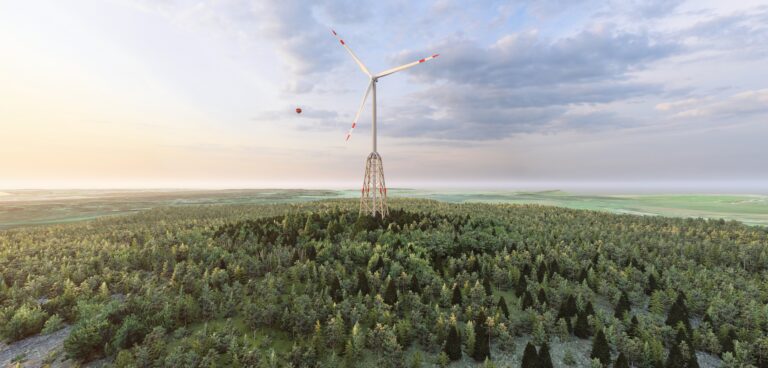 Wood-hybrid tower of a wind turbine in a green landscape, surrounded by trees and meadows. © vom-creations.com